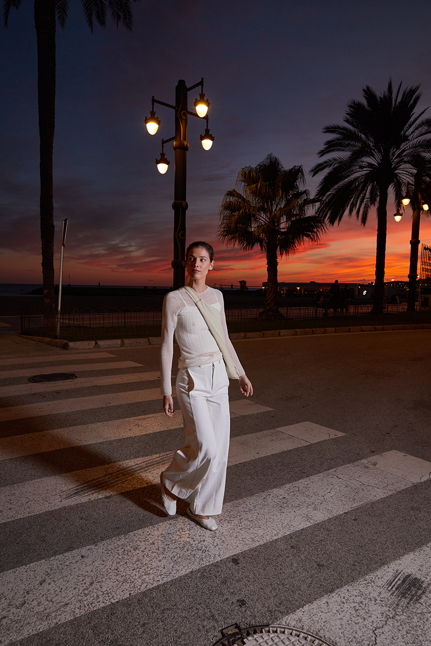 Model walking through the town of sitges during the sunset