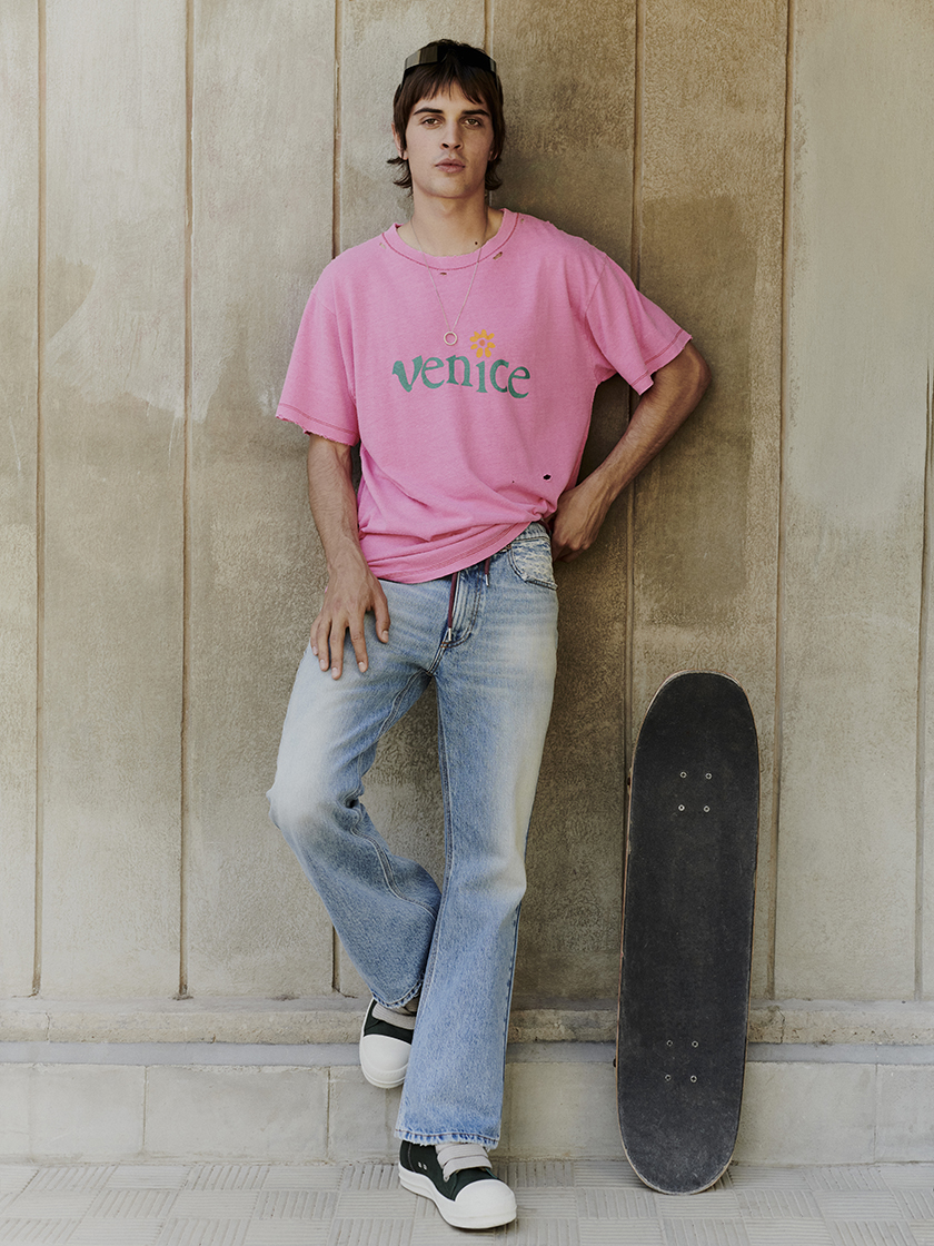 Model leaning on the wall with a skateboard in Tenerife for the Harvey Nichols shopping centre summer campaign