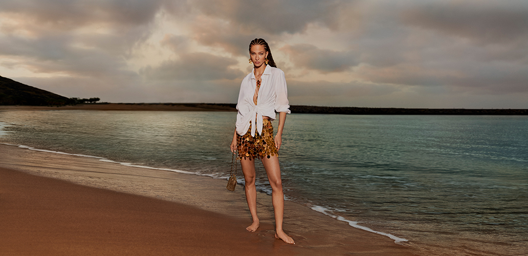 Model on a beach at sunrise for the Harvey Nichols shopping centre summer campaign