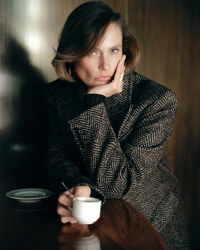 Model dressed in office attire with a cup of coffee for the editorial "Back on truck" for Instyle Spain.