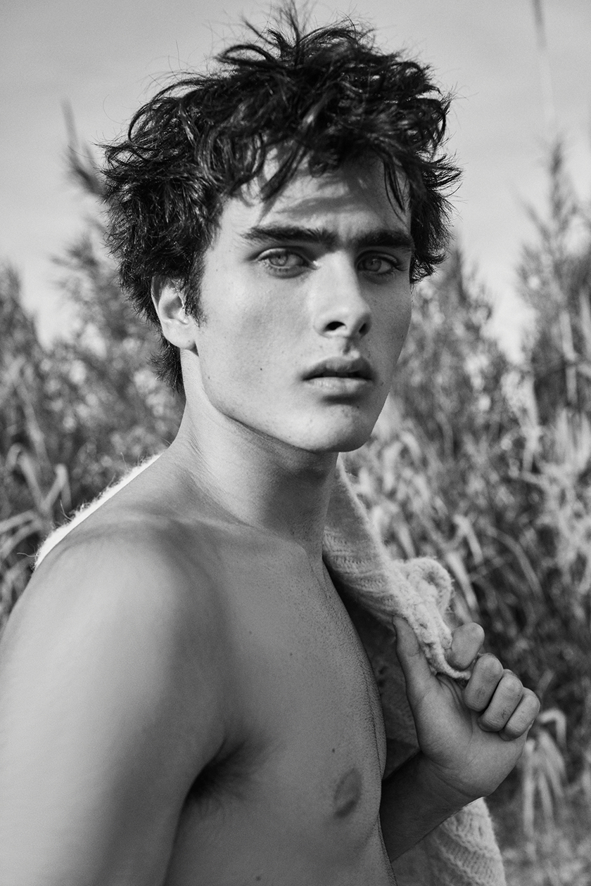 Short shot black and white of shirtless model Juan Reyes in a park 