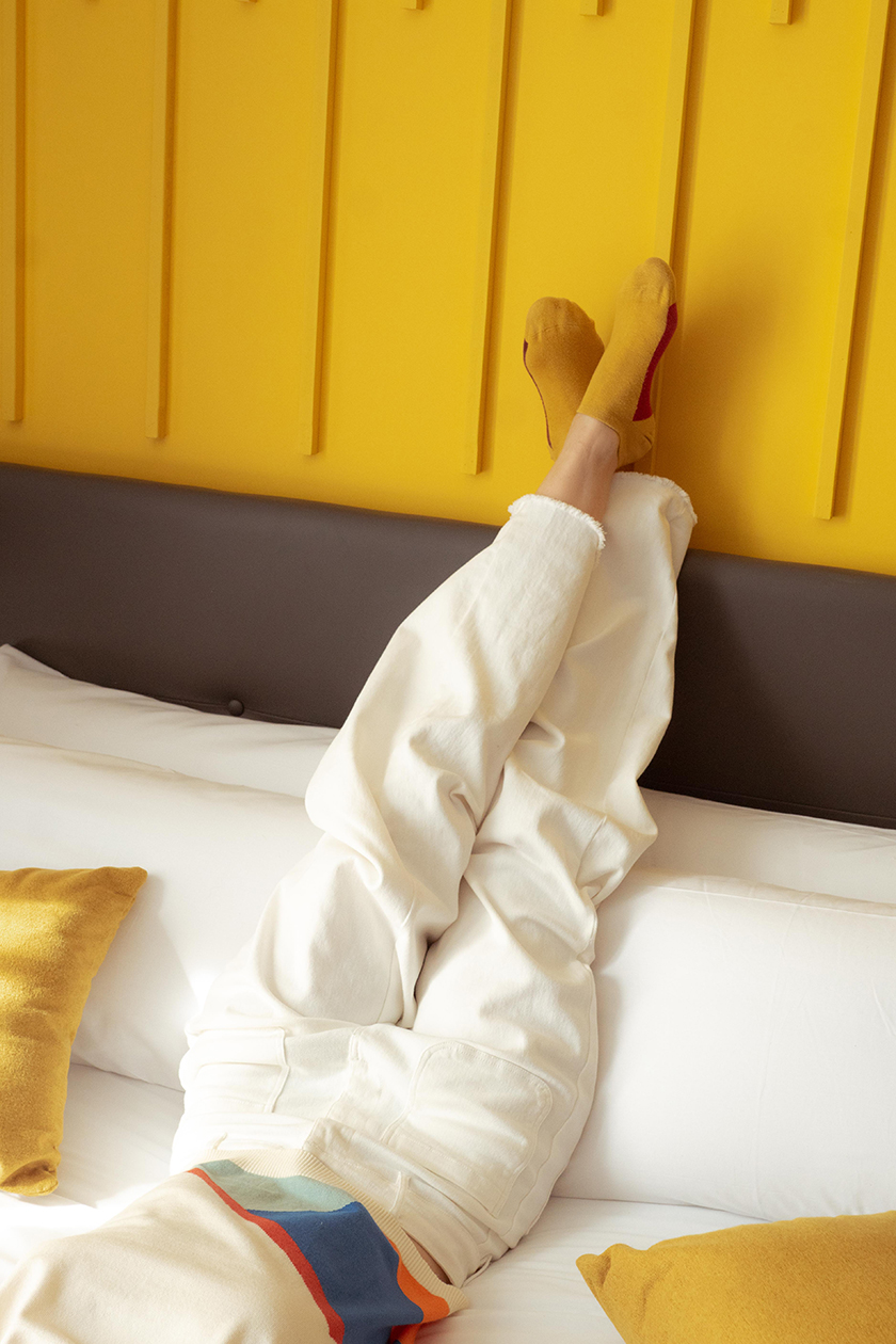 Photo of legs on top of a yellow wall in one of the Bypillow beds. 