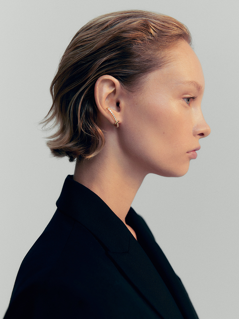 Profile of a woman, wearing a branded earring