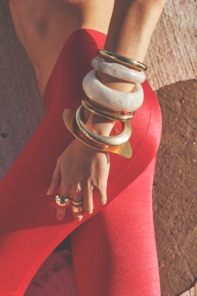 Photo of a girl's waist with leggings and arm showing bracelets