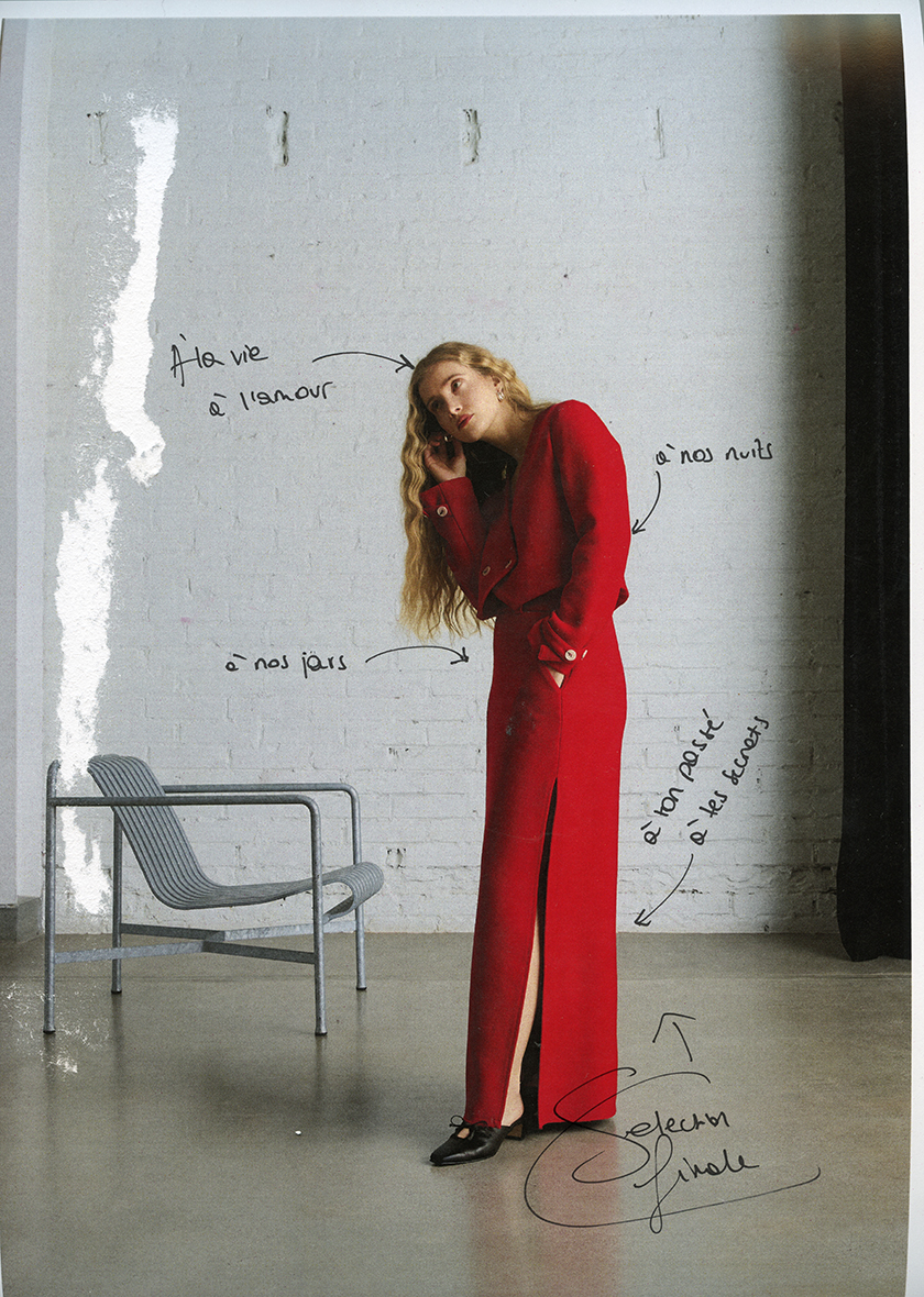 Model in a red suit in an apatrament.