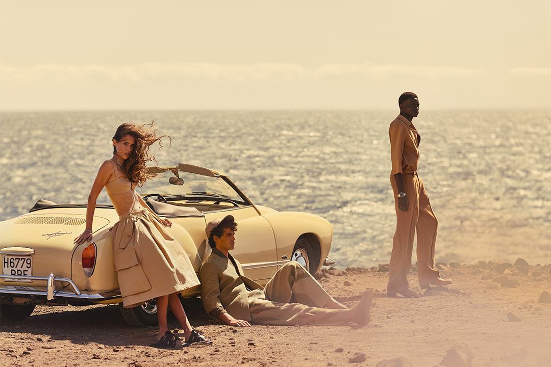 Three models pose on the beach next to a car for GQ Magazine