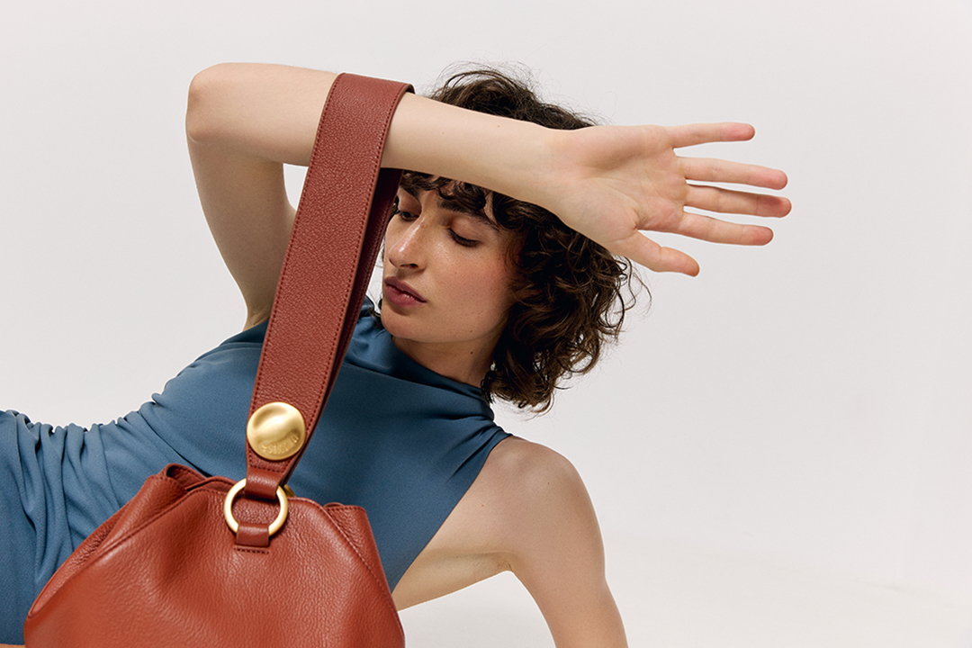 Stretched model showing a brown Esthera handbag. 