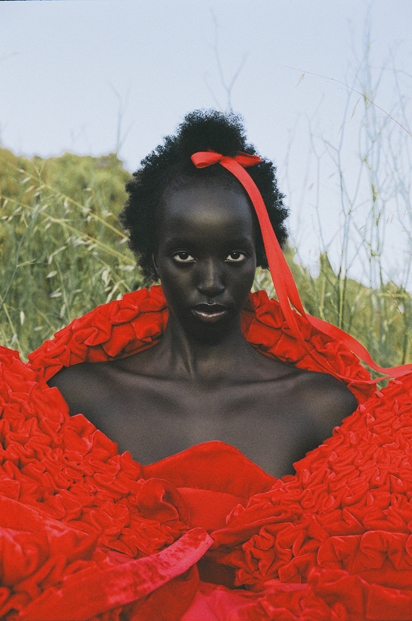 Close-up of model Nyaueth in a red dress for Numéro Netherlands magazine.