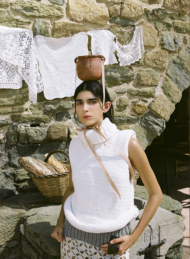 Model with a vase on her head in a white outfit for the magazine Numéro Netherlands. 