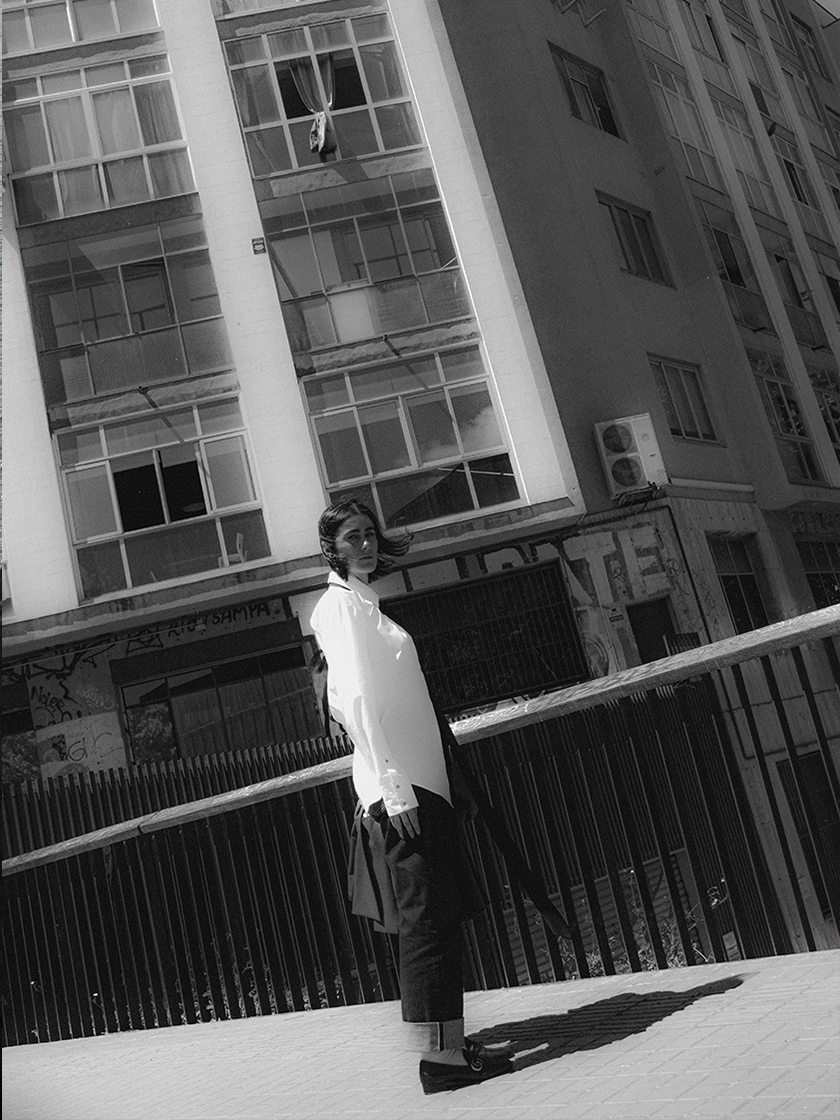 Black and white image with a girl looking at the camera in the city of Barcelona.