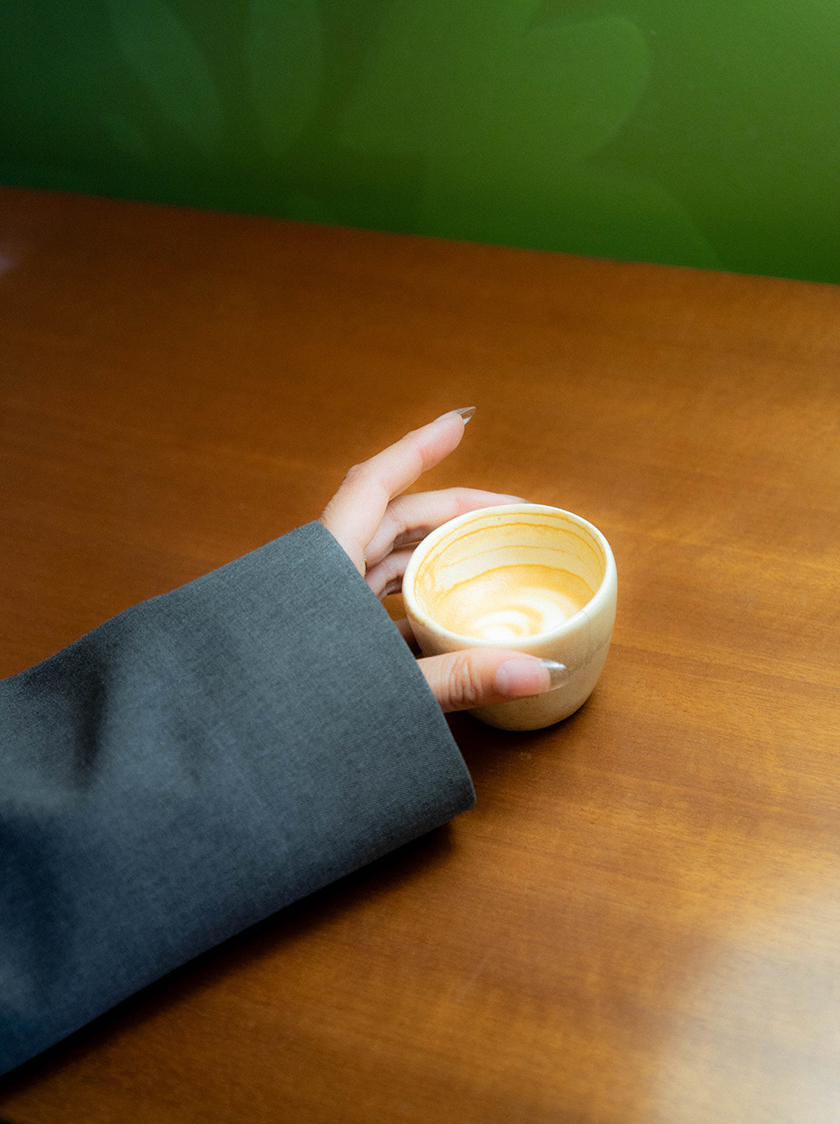 Hand of a person holding a coffee cup.