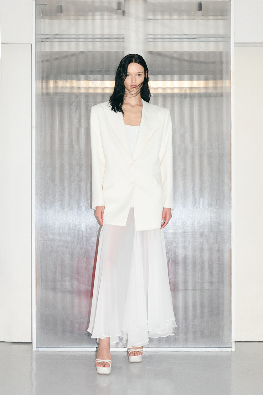 Model wearing a white suit and skirt from the new collection of the haute couture brand. 