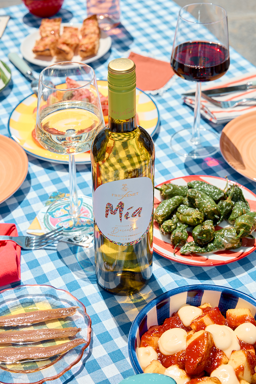 Image of a table full of food with a bottle of Freixenet's Mía brand wine.